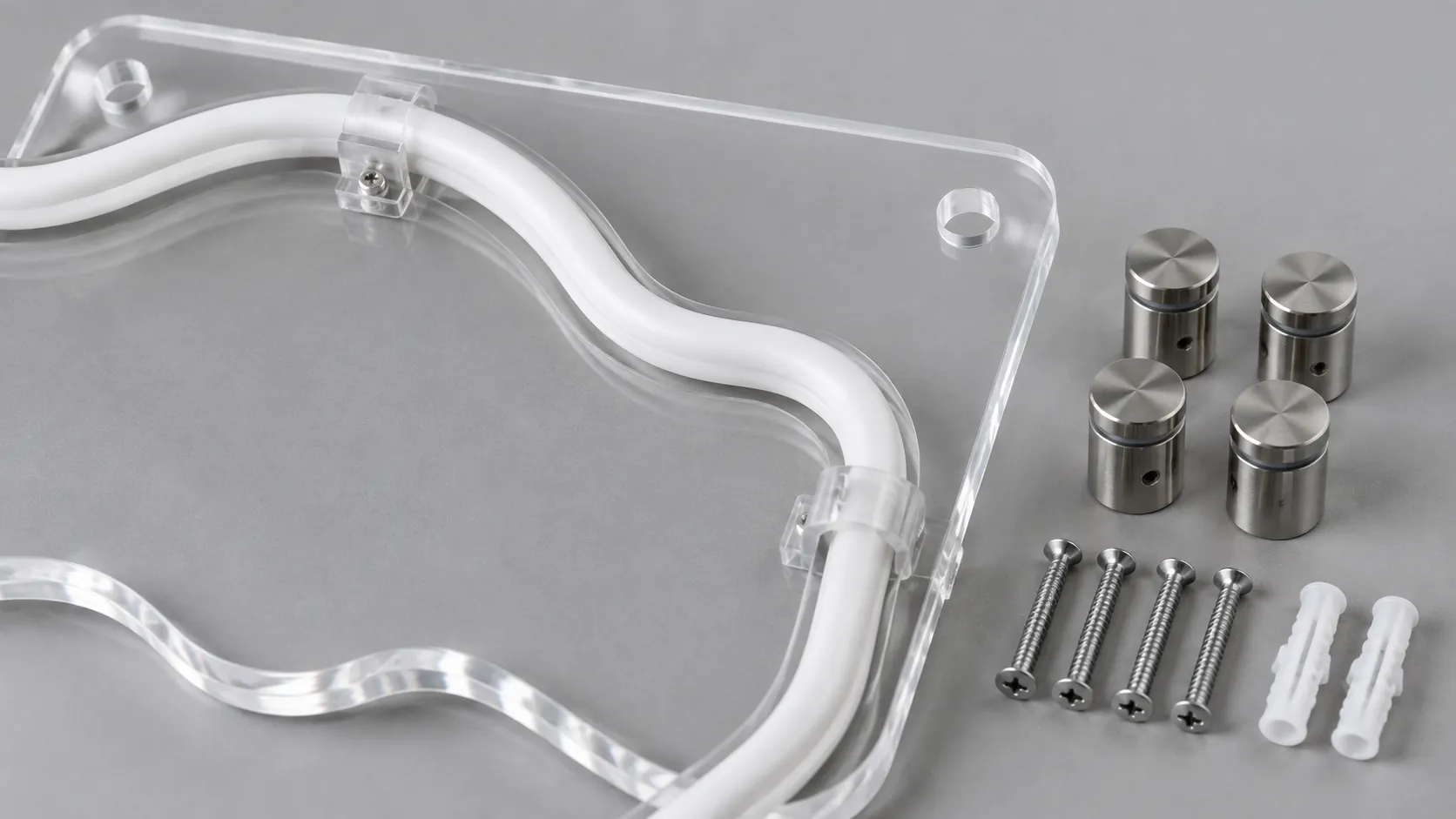Clear acrylic sign backing with an unlit neon tube clipped along it, beside standoff barrels and wall anchors