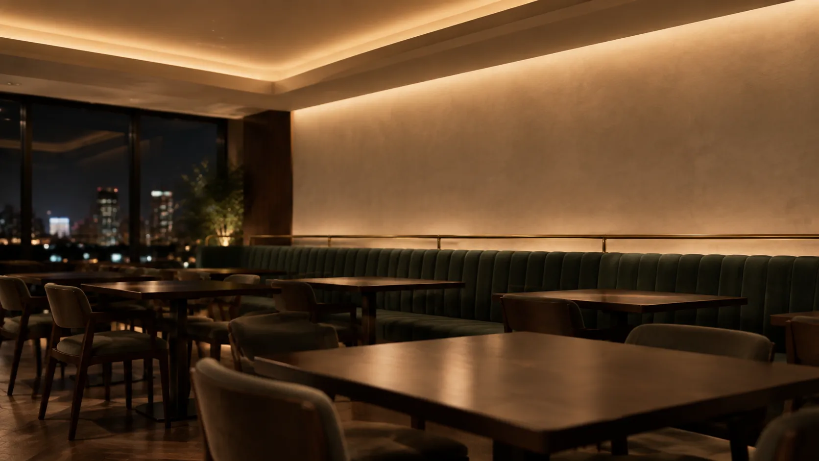 Restaurant with a stepped perimeter ceiling drop lighting the ceiling and a washed plaster wall beyond