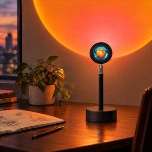 Black desk sunset projection lamp with a metal swivel joint casting an orange sunset glow on the wall