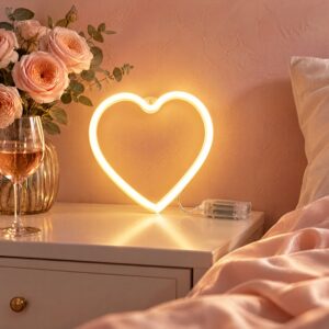 Warm white heart shaped neon light on a bedside table, wired to a clear battery box